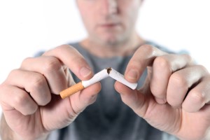 Man breaking cigarette in half